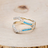 Shown here is "Raya", ring guard, a custom, handcrafted ring featuring turquoise inlays and diamond accents, facing left.