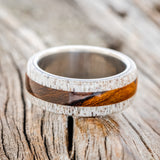Shown here is "Canyon", a custom, handcrafted men's wedding ring featuring elk antler overlays with an ironwood inlay, laying flat. Additional overlay and inlay options are available upon request.