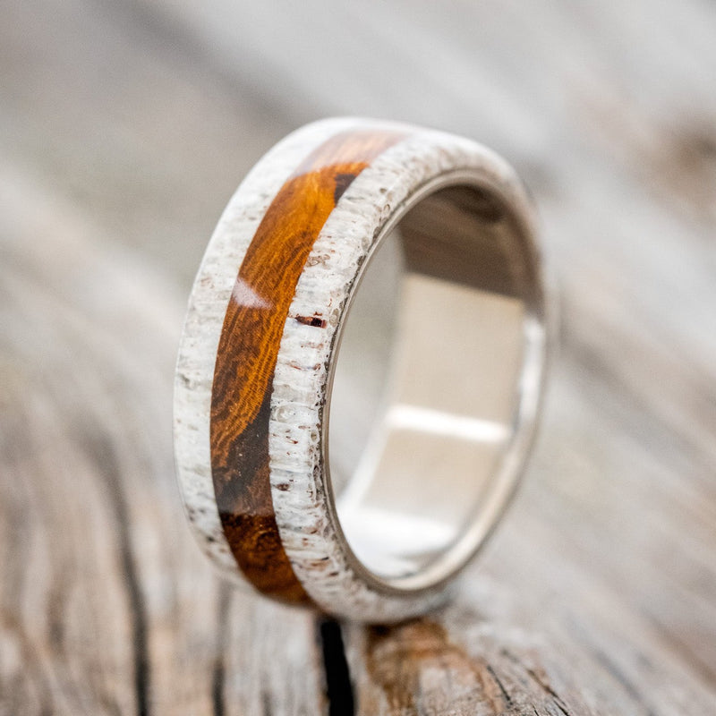 Shown here is "Canyon", a custom, handcrafted men's wedding ring featuring elk antler overlays with an ironwood inlay, upright facing left. Additional overlay and inlay options are available upon request.