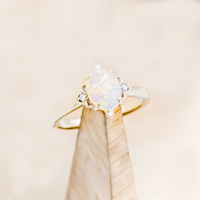 Shown here is "Zella", a white opal women's engagement ring with diamond accents, on stand facing slightly right. Many other center stone options are available upon request.