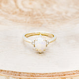 Shown here is "Zella", a white opal women's engagement ring with diamond accents, front facing. Many other center stone options are available upon request.