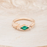 Shown here is "Sparrow", a lab-created emerald women's engagement ring with a sparrow embellishment, front facing. Many other center stone options are available upon request.