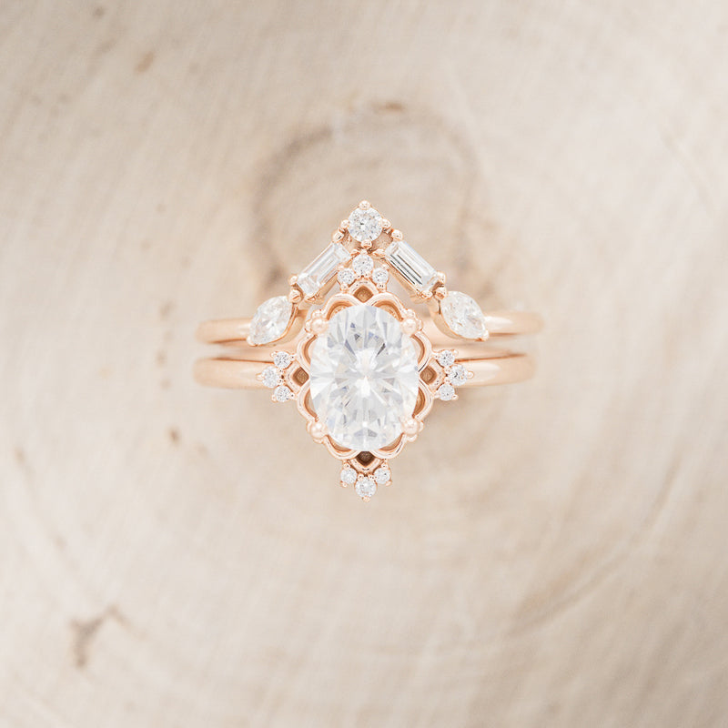 Shown here is "Treva", an oval moissanite women's engagement ring set with diamond accents and a "Melody" tracer, upright. Many other center stone options are available upon request.