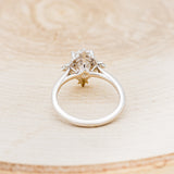 Shown here is "Treva", an oval moissanite women's engagement ring set with diamond accents, back view. Many other center stone options are available upon request.
