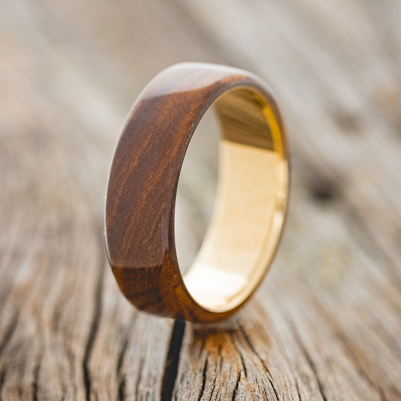 Shown here is "Haven", a custom, handcrafted men's wedding ring featuring an ironwood overlay, upright facing left. Additional inlay options are available upon request.