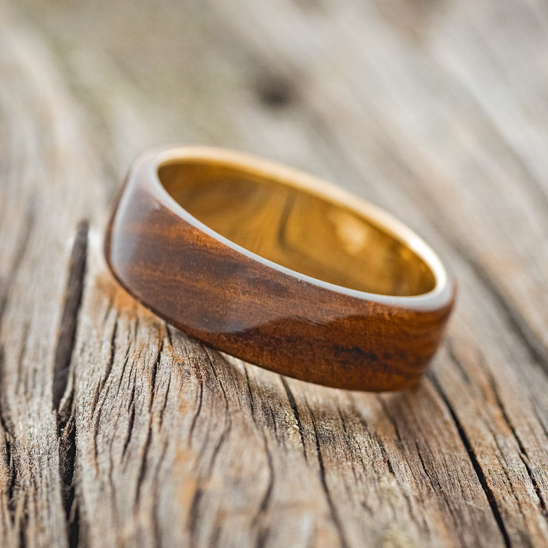 Shown here is "Haven", a custom, handcrafted men's wedding ring featuring an ironwood overlay, tilted left. Additional inlay options are available upon request.