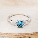 Shown here is "Blossom", a turquoise women's engagement ring with leaf-shaped diamond accents, front facing. Many other center stone options are available upon request.
