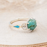 Shown here is "Lucy in the Sky", a halo-style hexagon turquoise women's engagement ring with diamond accents and turquoise inlays, facing right. Many other center stone options are available upon request.