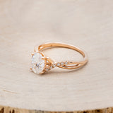 Shown here is "Roslyn", an oval moissanite women's engagement ring with diamond accents, facing left. Many other center stone options are available upon request.