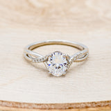 Shown her is "Roslyn", an oval moissanite women's engagement ring with diamond accents, front facing. Many other center stone options are available upon request.