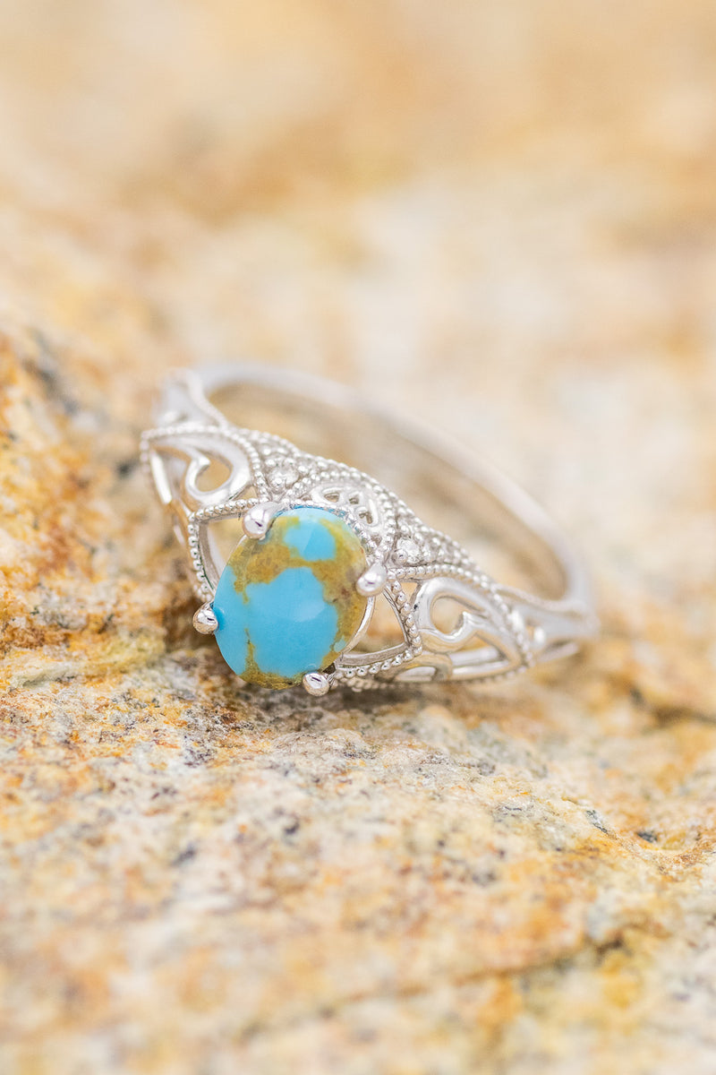 Shown here is The "Relica", a vintage-style turquoise women's engagement ring with delicate and ornate details and is available with many center stone options.