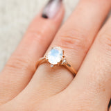 Shown here, Zella, an oval moonstone women's engagement ring with diamond accents, on hand. Many other center stone options are available upon request. 