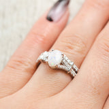Shown here, Evlin a split shank opal women's engagement ring with diamond accents and a diamond tracer, on hand. Many other center stone options are available upon request. 