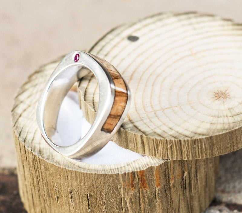 Shown here is a tilted angle of "Mesa", a custom, handcrafted men's wedding band featuring spalted maple and two offset rubies. Additional inlay options are available upon request.-CUSTOM CAST SILVER WEDDING BAND FEATURING SPALTED MAPLE AND RUBIES (available in silver or 14K white, yellow, or rose gold) - Staghead Designs - Antler Rings By Staghead Designs