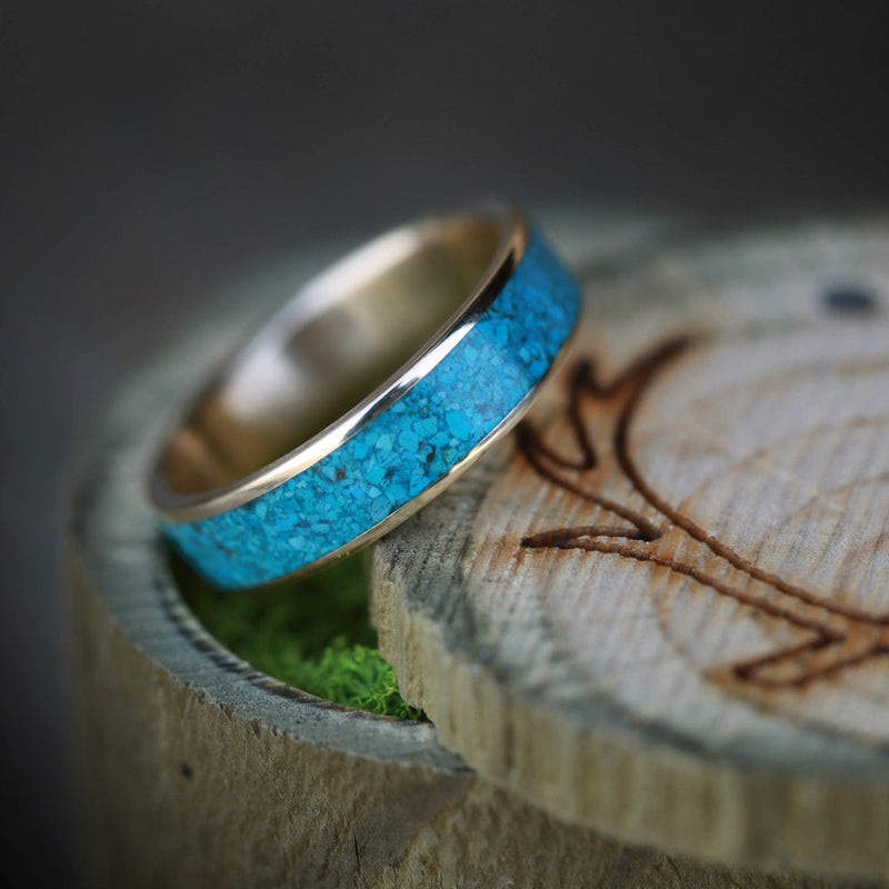 Shown here is "Rainier", a custom, handcrafted men's wedding ring featuring a crushed turquoise inlay, tilted left. Additional inlay options are available upon request.